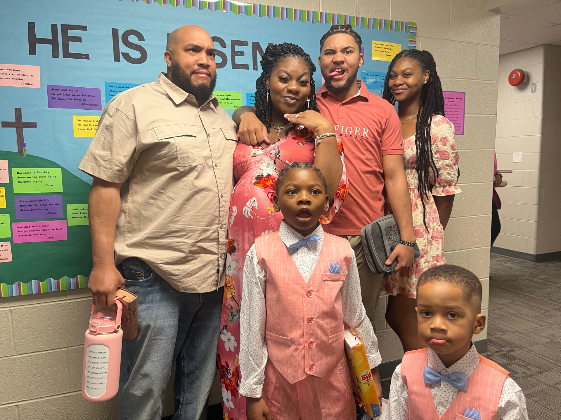 Calvin with his wife and children in front of a church bulletin board